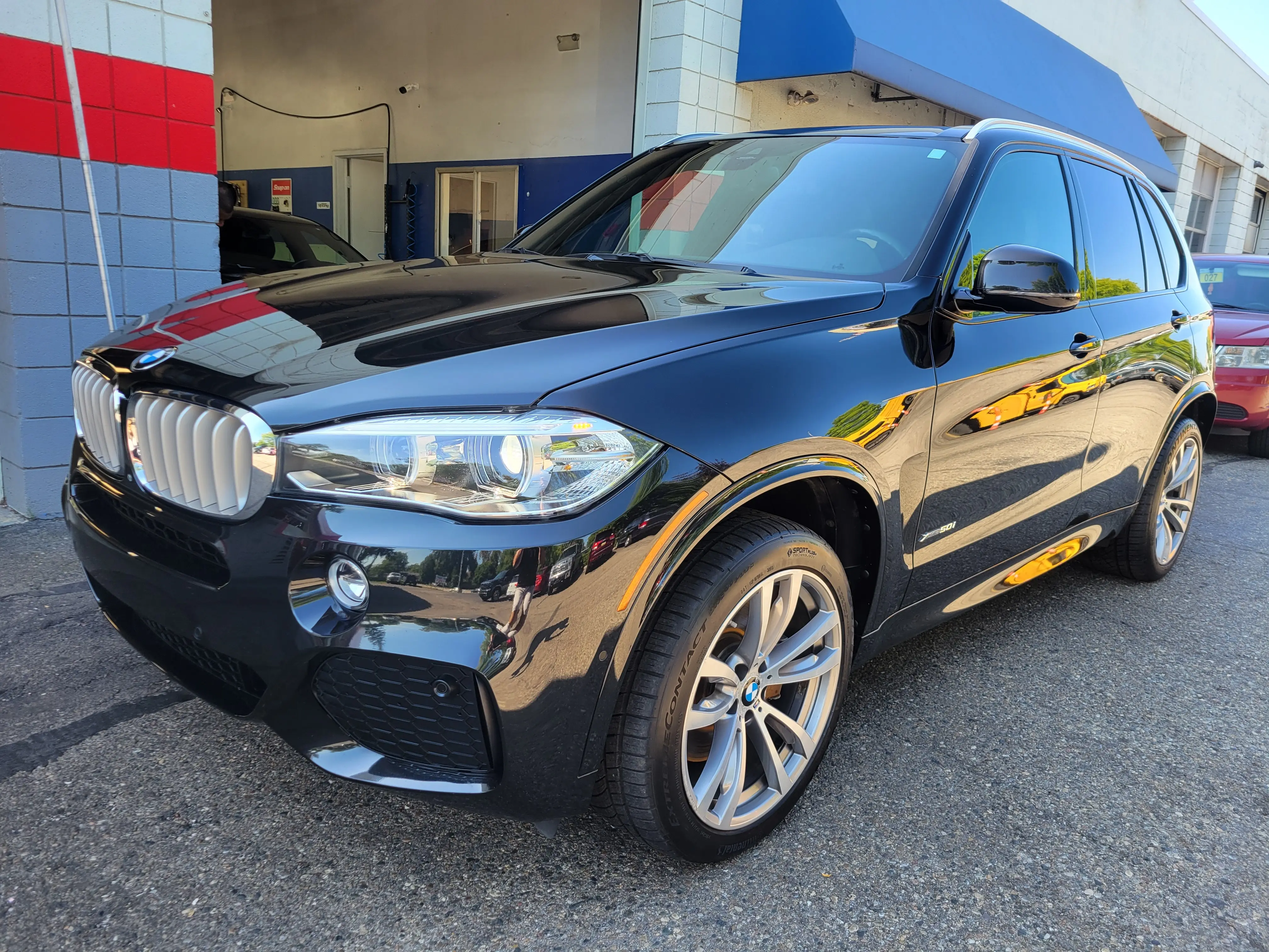 The same BMW X5 after detailing and ceramic coating, cleaned and polished to a mirror black finish